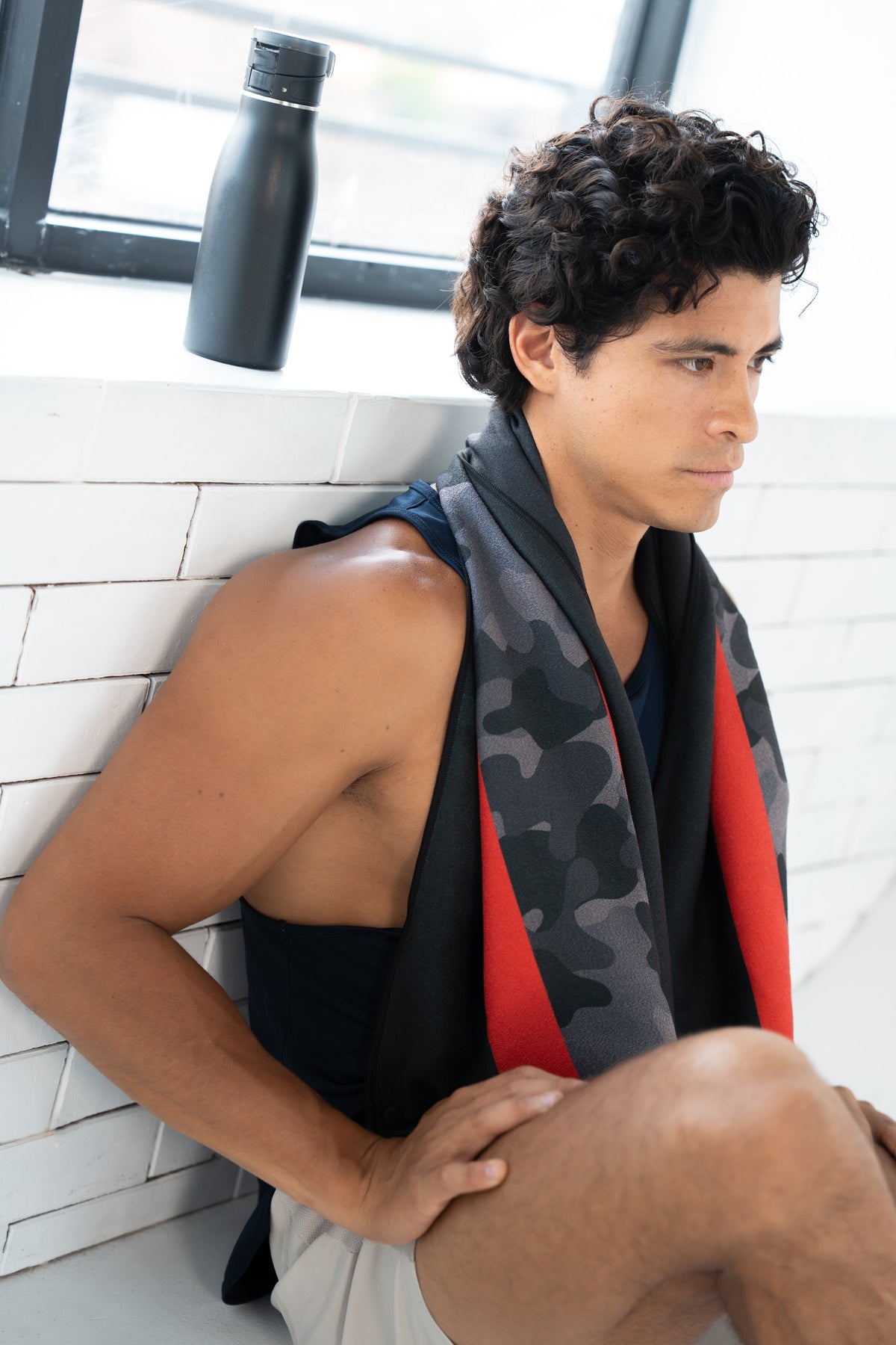Mann im Gym mit dem Sporthandtuch Redline von Woods & Waves über den Schultern